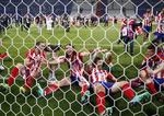 Jugadores del Atlético celebran después del juego con el trofeo en sus manos.