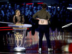 Kristen Bell, a la izquierda, observa mientras Seth Rogen muestra un tatuaje falso de Vin Diesel mientras presenta el mejor espectáculo de comedia.