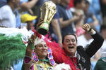 Aficionados mexicanos, uno sosteniendo una imitación de la Copa del Mundo.