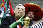 Los fanáticos mexicanos, uno con la máscara del recién electo presidente de México, Andrés López Obrador, aplauden antes de la ronda de 16 partidos entre Brasil y México en la Copa Mundial de fútbol 2018 en el Samara Arena.