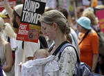 Una mujer porta una pancarta y un bebé durante la Marcha de Mujeres 'Stop Trump' en Londres.