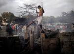 Un joven observa los restos de unas chabolas calcinadas tras un incendio de una zona deprimida en Paranaque.