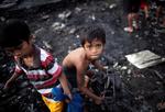 Un joven observa los restos de unas chabolas calcinadas tras un incendio de una zona deprimida en Paranaque.