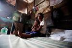 Elena Valeña y su hija descansan en el interior de su casa en una zona deprimida de Quezon.