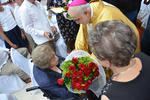 El obispo bajó hasta donde estaba para entregarle un ramo de flores.