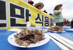 Muchos surcoreanos creen que comer carne de perro o caldo de pollo les da la fuerza para superar el calor.