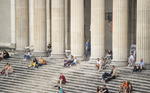 La gente disfruta del sol en las escaleras del palacio de la Colección de Antigüedades en la Koenigsplatz 