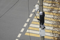 A demonstrator tries to dismantle a security camera on a pole during a protest in Almaty, Kazakhstan, Wednesday, Jan. 5, 2022. Demonstrators denouncing the doubling of prices for liquefied gas have clashed with police in Kazakhstan's largest city and held protests in about a dozen other cities in the country. (AP Photo/Vladimir Tretyakov)