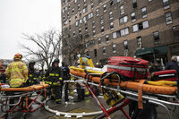 Firefighters work outside an apartment building after a fire in the Bronx, Sunday, Jan. 9, 2022, in New York. (AP Photo/Yuki Iwamura)