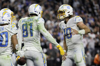 Los Angeles Chargers quarterback Justin Herbert (10) celebrates after throwing a touchdown pass to wide receiver Mike Williams (81) during the second half of an NFL football game, Sunday, Jan. 9, 2022, in Las Vegas. (AP Photo/Ellen Schmidt)