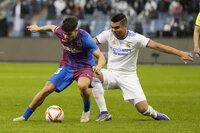 Barcelona's Abdessamad, left, and Real Madrid's Casemiro fight for the ball during the Spanish Super Cup semi final soccer match between Barcelona and Real Madrid at King Fahd stadium in Riyadh, Saudi Arabia, Thursday, Jan. 13, 2022. (AP Photo/Hassan Ammar)