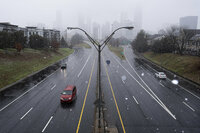 Large snowflakes fall and obscure the Downtown Atlanta skyline as a winter storm rolls into the area Sunday, Jan. 16, 2022. (AP Photo/Ben Gray)