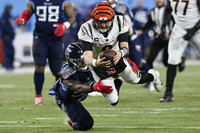 Cincinnati Bengals quarterback Joe Burrow (9) leaps for a first down against Tennessee Titans inside linebacker Jayon Brown (55) during the second half of an NFL divisional round playoff football game, Saturday, Jan. 22, 2022, in Nashville, Tenn. (AP Photo/Mark Zaleski)