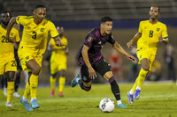 Mexico's Carlos Antuna dribbles past Jamaica's Ethan Pinnock (3) during a qualifying soccer match for the FIFA World Cup Qatar 2022 in Kingston, Jamaica, Thursday, Jan. 27, 2022. (AP Photo/Ramon Espinosa)
