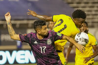 Mexico's Jesus Corona (17) and Jamaica's Javain Brown battle for the ball during a qualifying soccer match for the FIFA World Cup Qatar 2022 in Kingston, Jamaica, Thursday, Jan. 27, 2022. (AP Photo/Ramon Espinosa)
