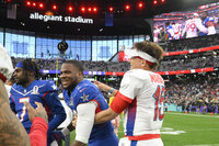 NFC inside linebacker Micah Parsons, left, of the Dallas Cowboys, reacts with AFC safety Derwin James (33), of the Los Angeles Chargers, after the Pro Bowl NFL football game, Sunday, Feb. 6, 2022, in Las Vegas. (AP Photo/David Becker)