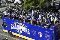 Buses carrying Los Angeles Rams players and coaches drive past fans during the team's victory parade in Los Angeles, Wednesday, Feb. 16, 2022, following their win Sunday over the Cincinnati Bengals in the NFL Super Bowl 56 football game. (AP Photo/Kyusung Gong)