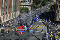 A bus carrying Los Angeles Rams players and coaches drives past fans during the team's victory parade in Los Angeles, Wednesday, Feb. 16, 2022, following their win Sunday over the Cincinnati Bengals in the NFL Super Bowl 56 football game. (AP Photo/Kyusung Gong)