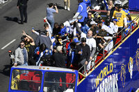 Buses carrying Los Angeles Rams players and coaches drive past fans during the team's victory parade in Los Angeles, Wednesday, Feb. 16, 2022, following their win Sunday over the Cincinnati Bengals in the NFL Super Bowl 56 football game. (AP Photo/Kyusung Gong)