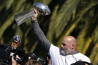 A bus carrying Los Angeles Rams players and coaches drives past fans during the team's victory parade in Los Angeles, Wednesday, Feb. 16, 2022, following their win Sunday over the Cincinnati Bengals in the NFL Super Bowl 56 football game. (AP Photo/Kyusung Gong)