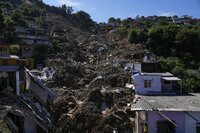A bulldozer clears out a street in an area affected by landslides in Petropolis, Brazil, Thursday, Feb. 17, 2022. Rio de Janeiro state’s government has confirmed 94 deaths from floods and mudslides that swept away homes and cars in the city of Petropolis but It’s still unclear how many bodies remained trapped in the mud. (AP Photo/Silvia Izquierdo)