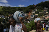 Residents carry their belongs in an area affected by landslides in Petropolis, Brazil, Thursday, Feb. 17, 2022.  Deadly floods and mudslides swept away homes and cars, but even as families prepared to bury their dead, it was unclear how many bodies remained trapped in the mud. (AP Photo/Silvia Izquierdo)