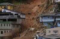 Residents carry their belongs in an area affected by landslides in Petropolis, Brazil, Thursday, Feb. 17, 2022.  Deadly floods and mudslides swept away homes and cars, but even as families prepared to bury their dead, it was unclear how many bodies remained trapped in the mud. (AP Photo/Silvia Izquierdo)