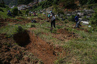 Cemetery workers dig graves at the Municipal Cemetery to bury the victims of mudslides in Petropolis, Brazil, Thursday, Feb. 17, 2022. Deadly floods and mudslides swept away homes and cars, but even as families prepared to bury their dead, it was unclear how many bodies remained trapped in the mud. (AP Photo/Silvia Izquierdo)