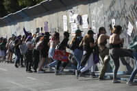 MEX7683. CIUDAD DE MÉXICO (MÉXICO), 08/03/2022.- Mujeres y activistas se protegen hoy de los gases de los extintores lanzados por la policía para dispersarlas, durante las manifestaciones por el Día Internacional de la Mujer en el Zócalo de la Ciudad de México. Miles de mujeres marcharon este martes por las principales ciudades de México para conmemorar el Día Internacional de la Mujer y exigir seguridad en un país en el que asesinan a más de 10 mujeres al día en medio de una radicalización del movimiento feminista y numerosas críticas hacia las autoridades. EFE/Sáshenka Gutiérrez