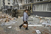 Kyiv (Ukraine), 04/04/2022.- A woman carries food in front of a damaged residential building in Bucha city, which was the recaptured by the Ukrainian army, Kyiv (Kiev) area, Ukraine, 04 April 2022. More than 410 bodies of killed civilians were carried from the recaptured territory in Kyiv's area for exgumation and expert examination. The UN Human Rights Council has decided to launch an investigation into the violations committed after Russia's full-scale invasion of Ukraine as Ukrainian Parliament reported. On 24 February, Russian troops had entered Ukrainian territory in what the Russian president declared a 'special military operation', resulting in fighting and destruction in the country, a huge flow of refugees, and multiple sanctions against Russia. (Rusia, Ucrania) EFE/EPA/OLEG PETRASYUK ATTENTION: GRAPHIC CONTENT