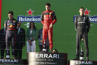 Ferrari driver Charles Leclerc of Monaco celebrates after winning the Australian Formula One Grand Prix as third placed Mercedes driver George Russell, right, of Britain watches in Melbourne, Australia, Sunday, April 10, 2022. (AP Photo/Asanka Brendon Ratnayake)