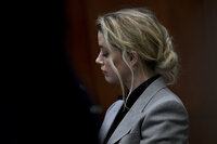 Actress Amber Heard listens inside the courtroom at the Fairfax County Circuit Court, April 12, 2022, in Fairfax, Va. A jury in Virginia is scheduled to hear opening statements in a defamation lawsuit filed by Johnny Depp against his ex-wife, Amber Heard. (Brendan Smialowski, Pool via AP)