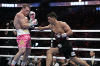 Dmitry Bivol, right, of Kyrgyzstan, throws a punch against Canelo Alvarez, of Mexico, during a light heavyweight title fight, Saturday, May 7, 2022, in Las Vegas. (AP Photo/John Locher)