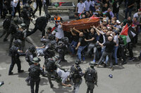 Israeli police confront with mourners as they carry the casket of slain Al Jazeera veteran journalist Shireen Abu Akleh during her funeral in east Jerusalem, Friday, May 13, 2022. Abu Akleh, a Palestinian-American reporter who covered the Mideast conflict for more than 25 years, was shot dead Wednesday during an Israeli military raid in the West Bank town of Jenin. (AP Photo/Maya Levin)