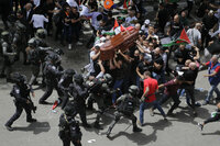 La policía israelí confronta a los dolientes mientras llevan el ataúd de la periodista veterana de Al Jazeera asesinada, Shireen Abu Akleh, durante su funeral el viernes 13 de mayo de 2022 en Jerusalén oriental. (AP Foto/Maya Levin)