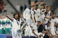 Real Madrid's Marcelo, left, gestures as holds the winning trophy end of the Champions League final soccer match between Liverpool and Real Madrid at the Stade de France in Saint Denis near Paris, Saturday, May 28, 2022. Real Madrid won 1-0. (AP Photo/Kirsty Wigglesworth)