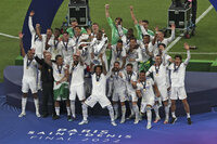 Real Madrid players celebrate with the trophy after winning the Champions League final soccer match between Liverpool and Real Madrid at the Stade de France in Saint Denis near Paris, Saturday, May 28, 2022. (AP Photo/Tony Hicks)