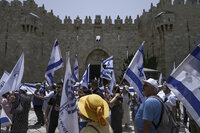 Israelis wave national flags in front of Damascus Gate outside Jerusalem's Old City to mark Jerusalem Day, an Israeli holiday celebrating the capture of the Old City during the 1967 Mideast war. Sunday, May 29, 2022. Israel claims all of Jerusalem as its capital. But Palestinians, who seek east Jerusalem as the capital of a future state, see the march as a provocation. Last year, the parade helped trigger an 11-day war between Israel and Gaza militants. (AP Photo/Mahmoud Illean)