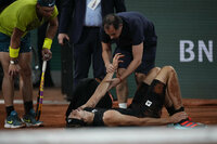 Germany's Alexander Zverev holds his right ankle after twisting it, as Spain's Rafael Nadal, left, looks on during their semifinal match at the French Open tennis tournament in Roland Garros stadium in Paris, France, Friday, June 3, 2022. (AP Photo/Christophe Ena)