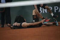 Germany's Alexander Zverev holds his right ankle after twisting it, as Spain's Rafael Nadal, left, looks on during their semifinal match at the French Open tennis tournament in Roland Garros stadium in Paris, France, Friday, June 3, 2022. (AP Photo/Christophe Ena)