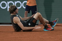 Germany's Alexander Zverev holds his right ankle after twisting it, as Spain's Rafael Nadal, left, looks on during their semifinal match at the French Open tennis tournament in Roland Garros stadium in Paris, France, Friday, June 3, 2022. (AP Photo/Christophe Ena)