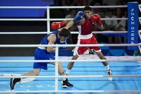 El uzbeco Asadkhuja Muydinkhujaev golpea al mexicano Marco Verde en la pelea de box olímpico, categoría de 71 kilogramos, el viernes 9 de agosto de 2024, en París (AP Foto/John Locher)