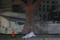 Melvin Lee Hicks, who is homeless, lies under a sheet donated by a nearby hotel, as he shelters alongside a parking garage in downtown Tampa, Fla., during the approach of Hurricane Milton, Wednesday, Oct. 9, 2024. (AP Photo/Rebecca Blackwell)