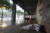 Ron Rook, who said he was looking for people in need of help or debris to clear, walks through windy and rainy conditions on a deserted street in downtown Tampa, Fla., during the approach of Hurricane Milton, Wednesday, Oct. 9, 2024. (AP Photo/Rebecca Blackwell)