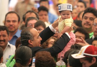 El presidente de México, Felipe Calderón Hinojosa, al participar en la celebración del 84 aniversario de la Unión de Expendedores y Voceadores de los Periódicos de México A.C., rechazó cualquier tipo de censura y reiteró su compromiso de respetar la libertad de expresión. En la gráfica el presidente Felipe Calderón carga a la hija de un voceador. (El Universal)
