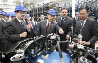 El presidente mexicano, Felipe Calderón observa las partes de un vehículo durante su recorrido por el parque industrial de proveedores del sector automotriz en Toluca, México, cuya inversión ha sido estimada en 134 millones de dólares. (EFE)