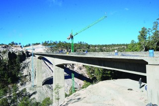Sin importar el frío, decenas de hombres trabajan en la construcción de la supercarretera Durango-Mazatlán.