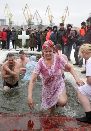Creyentes ortodoxos rusos se bañan en el agua helada durante la celebración de la Epifanía en Moscú, Rusia. (EFE)