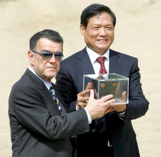 El presidente del Comité Olímpico Griego, Minos Kyriakou (izq.), le pasa el caldero de la llama olímpica al presidente del Comité Organizativo de los Juegos Olímpicos de Pekín 2008, Liu Qi, durante la ceremonia de encendido de la antorcha olímpica frente al templo de Hera en la Antigua Olimpia. (EFE)
