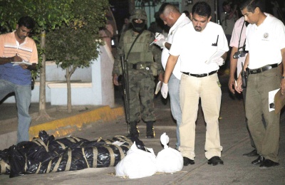 Expertos forenses realizan el levantamiento de cuatro personas decapitadas encontradas la noche de este 1 de julio de 2008, envueltas en mantas mientras que sus cabezas fueron dejadas en bolsas de plástico, en la colonia miguel alemán de la ciudad de culiacán, estado mexicano de sinaloa. (EFE)